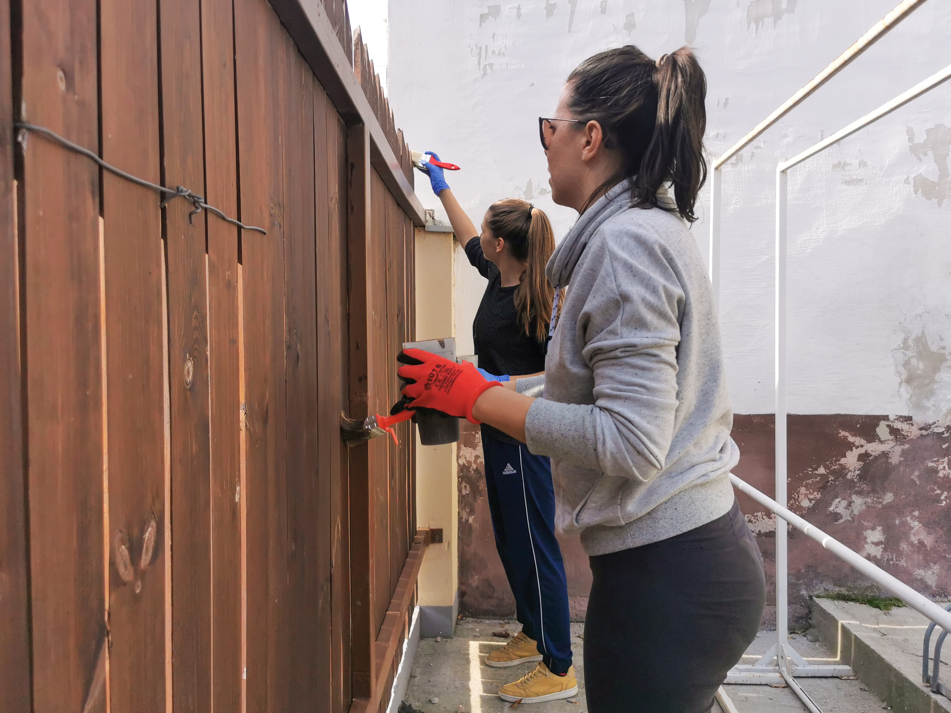 Két delaware munkavállaló festi Kecskeméten a kerítést társadalmi felelősségvállalási tevékenységünk keretein belül.