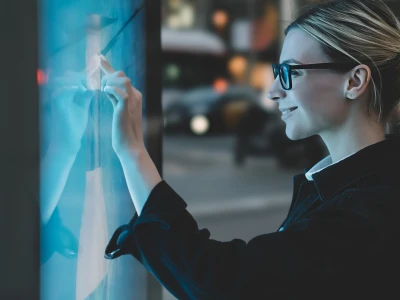 smartly dressed lady wearing glasses looking at whiteboard