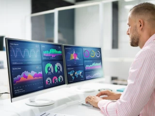 picture of a smartly dressed man looking at a analytics dashboard on a computer